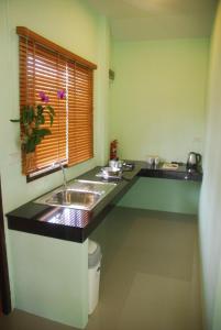 uma cozinha com um lavatório e uma janela em Anacar Bungalows em Krabi