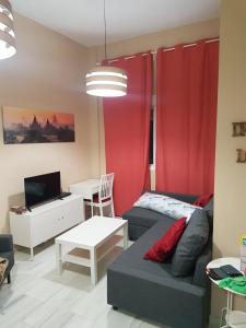 sala de estar con cortinas rojas y sofá en CENTRICO Y LUMINOSO CON 2 DORMITORIOS. A/C + WIFI, en Sevilla
