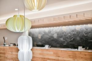 duas luzes pendentes brancas penduradas sobre um balcão em REF Kumamoto by VESSEL HOTELS em Kumamoto