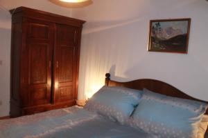 1 dormitorio con 1 cama y armario de madera en Ferienwohnung Salburg, Sonnleitn, en Hermagor