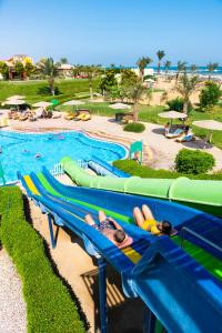 a beach area with a blue and yellow surfboard at The Three Corners Sunny Beach Resort in Hurghada