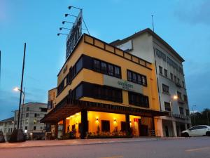 ein gelbes Gebäude an der Ecke einer Straße in der Unterkunft Goodhope Hotel Shah Alam in Shah Alam