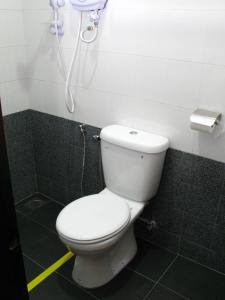 a bathroom with a toilet and a phone on the wall at Goodhope Hotel Shah Alam in Shah Alam