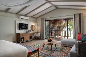 a hotel room with a king bed and a living room at Anantara Bazaruto Island Resort in Bazaruto