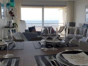 un tavolo con bicchieri da vino sopra di Superbe T2 avec vue mer à 2 min du centre ville (52m2) a Le Touquet-Paris-Plage