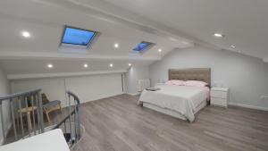 a bedroom with a bed and a staircase with windows at Fantástico apartamento, cerca de todo, para disfrutar de la ciudad in A Coruña