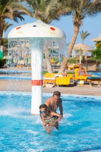 Three Corners Sunny Beach Resort في الغردقة: رجل وبنت في مسبح في حديقة مائية