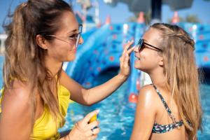twee meisjes die naar hun mobieltjes kijken bij een zwembad bij Three Corners Sunny Beach Resort in Hurghada