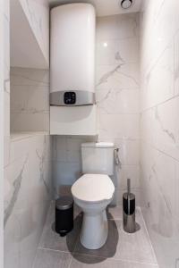 ein Bad mit einem WC und einer Uhr an der Wand in der Unterkunft CMG Reuilly- Diderot / Hôpital Saint-Antoine in Paris