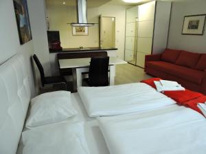 Zimmer mit 2 Betten, einem Sofa und einem Tisch in der Unterkunft 101 Athen, Studio Apartment, 38m2 1-4 Pers in Klagenfurt am Wörthersee