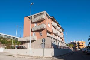 un edificio alto de color rosa con balcones en una calle en Residence Bonelli en Grassano