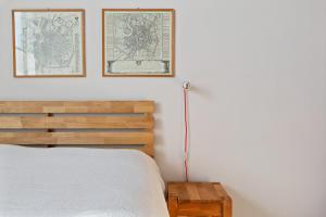 een slaapkamer met een bed en twee ingelijste kaarten aan de muur bij Bed & Breakfast San Calocero - private bathroom - Wi-Fi in Milaan