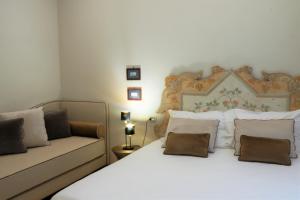 a bedroom with two beds and a couch at Casa Vittoria Napoli - Santa Lucia in Naples