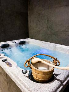 a bath tub with a bucket in a bath tub at Aparthotel Hornigold "W Zielonej Kamienicy" in Katowice