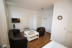 a living room with two chairs and a coffee table at Haus Bomhoff Sylt in Westerland