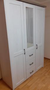 a white cabinet with a mirror on top of it at Preisbewusste Ferienwohnung für 2 Personen u. Kleinkind in Utarp
