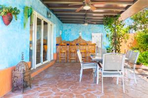 um pátio com uma mesa e cadeiras num quarto em Villa Golf Sanlucar em Sanlúcar de Barrameda