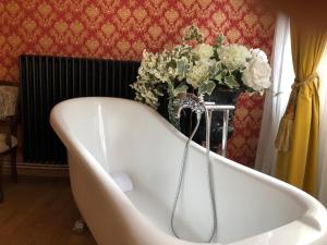 a white bath tub with a vase of flowers at Love Nest Versailles - Unique Louis XIV decoration - Calm location right IN city center in Namur