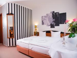 
a hotel room with a bed and a painting on the wall at Pension Weinberg Güstrow in Güstrow
