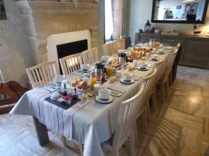 Martragny的住宿－La Charretterie，一张长桌,上面有食物和饮料