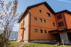 an orange building with a black roof at Apartman's Ana Pale-OC Jahorina in Pale