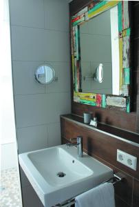 a bathroom with a white sink and a mirror at Hotel An der Linde in Neckarsulm