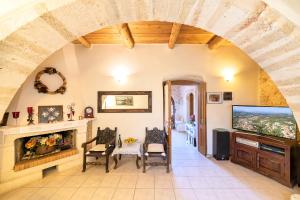 a living room with a fireplace and a tv at Villa Philia Crete in Gavalochori