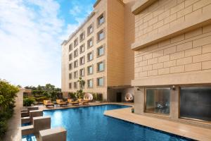 a hotel with a swimming pool in front of a building at Holiday Inn Agra MG Road an IHG Hotel in Agra