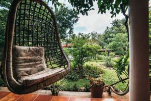 Gitanjali Homestay في ميسور: كرسي معلق على شرفة مع حديقة