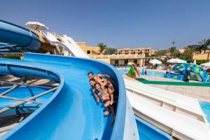 Three Corners Rihana Resort El Gouna في الغردقة: مجموعة من الناس ينزلقون على زحليقة مائية في حديقة مائية