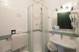 a bathroom with a shower and a toilet and a sink at Hotel Tirreno in Genoa