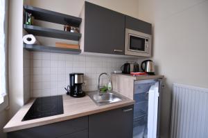 a small kitchen with a sink and a microwave at Apartment Nürnberg Like Home in Nürnberg