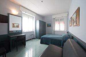 a bedroom with a bed and a desk and a couch at Hotel Tirreno in Genoa
