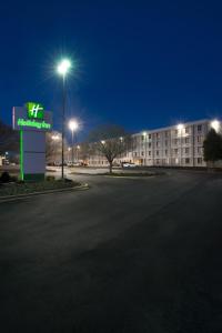 un estacionamiento frente a un edificio por la noche en Holiday Inn Charlotte Airport, an IHG Hotel, en Charlotte