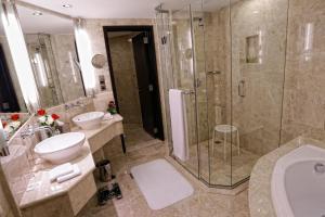 a bathroom with a shower, sink, and toilet at Ramada Plaza by Wyndham Dubai Deira in Dubai