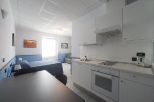 a kitchen and living room with a bed and a table at Hotel Tirreno in Genoa