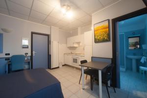 a room with a bed and a table and a kitchen at Hotel Tirreno in Genoa