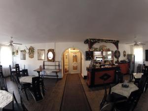 a room with tables and chairs and a yellow door at Olympos Panzi&oacute; in Buda&ouml;rs