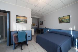 a bedroom with a blue bed and a desk at Hotel Tirreno in Genoa