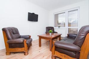 a living room with two chairs and a table and a tv at Apartmán Slezská in Frýdek-Místek