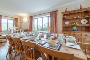 a dining room with a wooden table and chairs at Webbs Retreat in Wadebridge