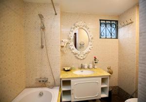 a bathroom with a sink and a tub and a mirror at Hanoi Hotel Royal in Hanoi