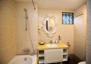 ein Badezimmer mit einem Waschbecken, einer Badewanne und einem Spiegel in der Unterkunft Hanoi Hotel Royal in Hanoi
