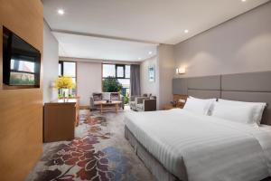 順義にあるRamada by Wyndham Beijing Airportのベッドルーム(大型ベッド1台付)、リビングルームが備わります。