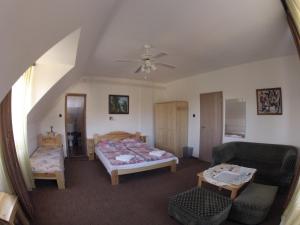 a bedroom with two beds and a ceiling fan at Olympos Panzió in Budaörs