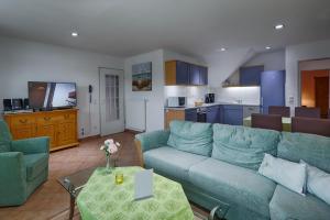 a living room with a blue couch and a kitchen at Feriendomizil Binz in Binz