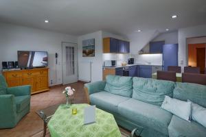 ein Wohnzimmer mit einem blauen Sofa und einer Küche in der Unterkunft Feriendomizil Binz in Binz