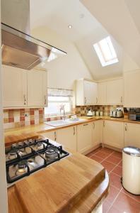a kitchen with a stove and a sink at Heron's Hideaway in Wells next the Sea