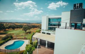 uma vista aérea de um edifício com piscina em Hospedium Hotel Valles de Gredos Golf em Talayuela