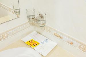 a bathroom with glasses and a book on a counter at Douangpraseuth Hotel in Vientiane